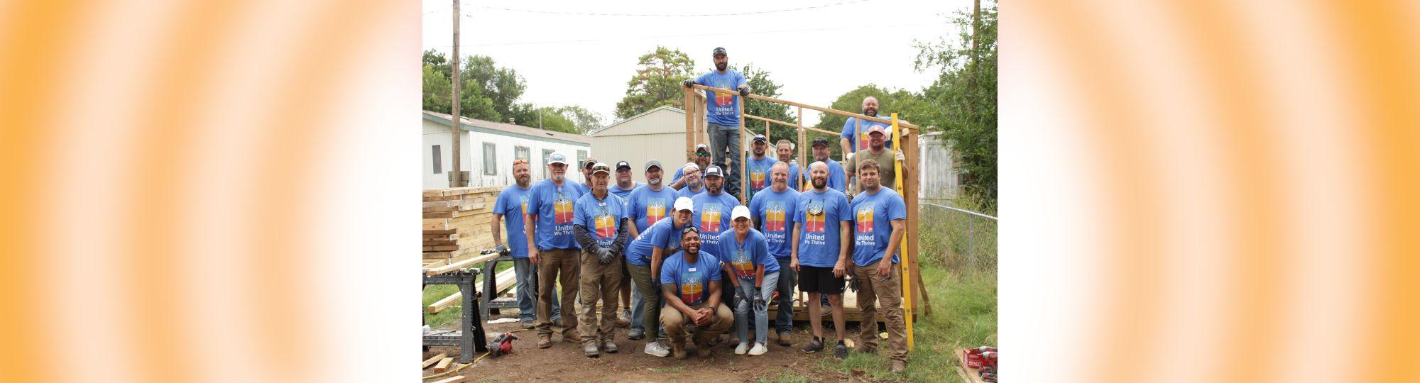 Kicker team stands in front of their Habitat for Humanity Project for Day of Caring
